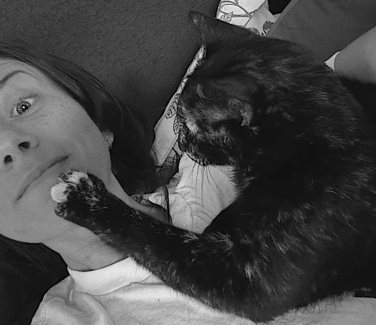 Tater Beans McGee lying face to face with Sam, one paw on her cheek